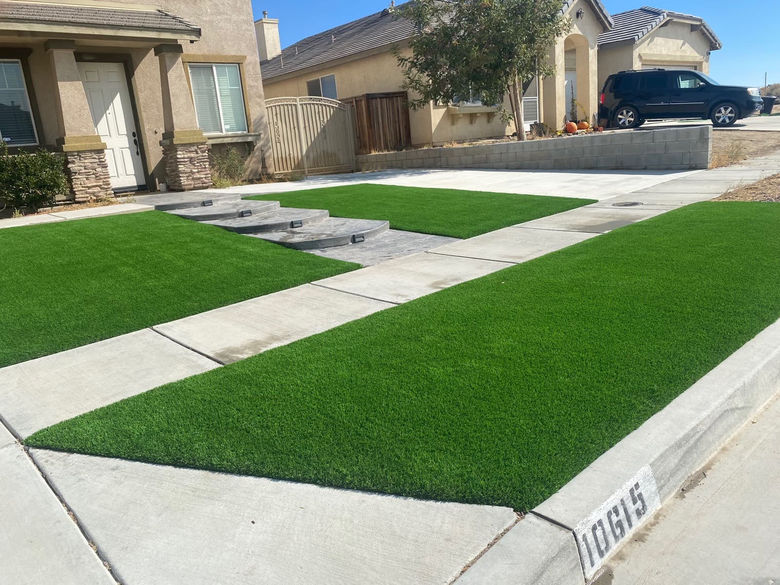 Front-yard turf strips along a sidewalk, steps, and driveway