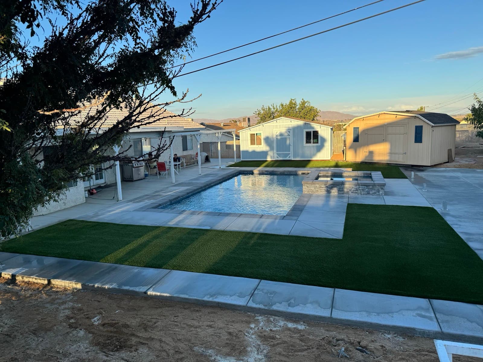 Pool deck with geometric turf panels around an in-ground pool and spa