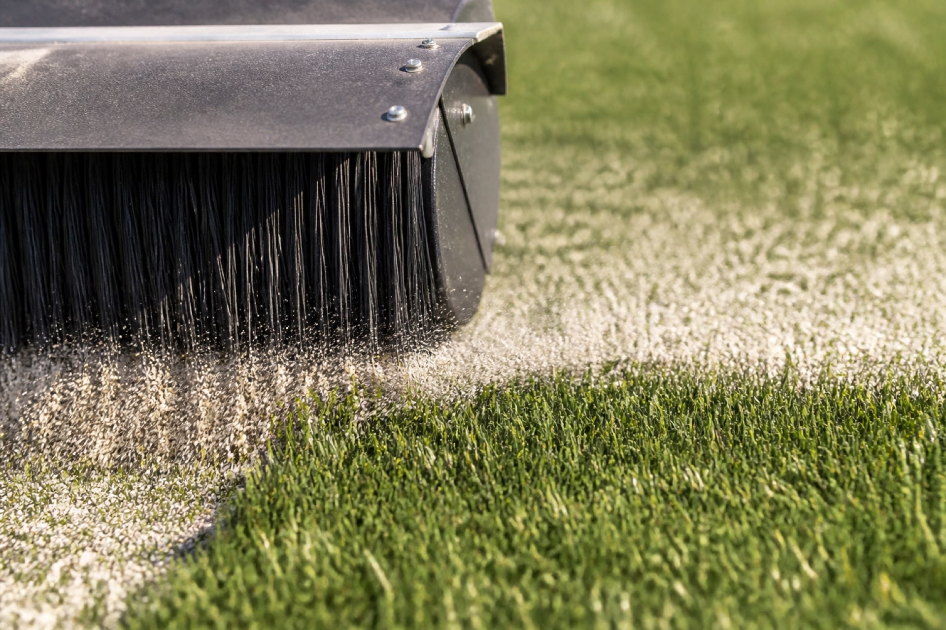 Infill brushed between artificial turf blades